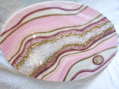 a pink and gold plate sitting on top of a white cloth