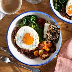 two bowls filled with food on top of a wooden table next to a cup of coffee