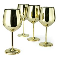 four gold wine goblets sitting next to each other