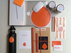 an assortment of items are displayed on a white surface with orange and black accents, including a computer mouse