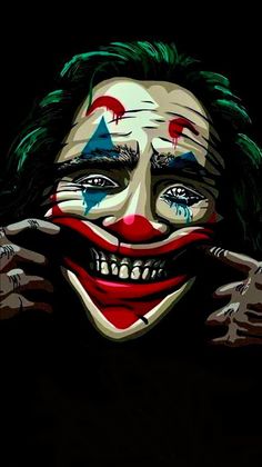 the joker is smiling and holding his hands up to his face with one eye open