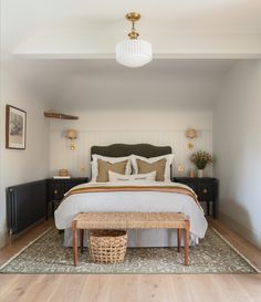 a bedroom with a bed, nightstands and a basket on the floor in front of it