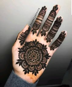 the hand is decorated with black henna