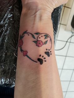 a woman's arm with a small heart tattoo on the left side of her wrist