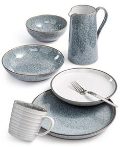 a set of dinnerware with blue speckles