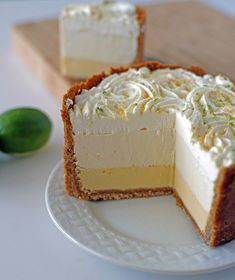 two pieces of cheesecake on a plate with limes in the backgroud