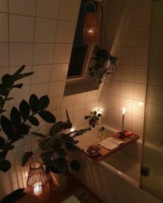 a bathroom with candles and plants in the bathtub