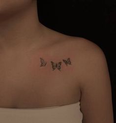 a woman with three butterflies on her shoulder