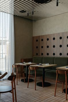 an empty restaurant with tables and chairs in front of a wall decorated with polka dots