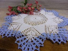 a crocheted doily with pink flowers on it