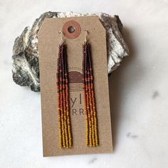 "A dreamy pumpkin spice inspired color fade with all of the warm colors of autumn. Embrace your inner bohemian goddess with our fan favorite long fringe beaded earrings.  Beautifully dramatic, comfortably lightweight. Enjoy the playful, free flowing style of beaded fringe earrings, without the weight.  Featuring 4 strands of hand woven matte glass beads. These unique matte glass beads have a very luxe look and feel to them.  Colors: These beaded earrings feature an ombre fade of matte mustard yellow, terra cotta and amethyst glass beads.  Length: Approximately 4\" drop length Metal Options: 14K Gold Fill or Sterling Silver (Gold-filled jewelry has 100x more gold alloy than gold plated and because that layer is so much thicker, it means gold-filled jewelry lasts longer and stands up to wear Handmade Bohemian Jewelry For Fall, Fringe Beaded Earrings, Colors Of Autumn, Beaded Fringe Earrings, Beaded Earrings Diy, Long Fringe, Gold Alloys, Beading Projects, Free Flowing