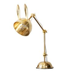 a gold lamp with a diamond in the shape of a rabbit's head on it