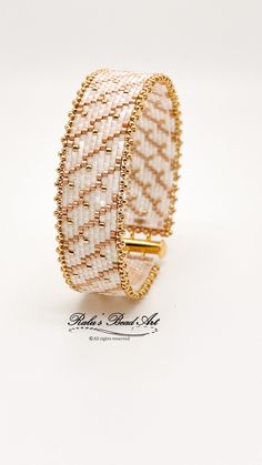 a white and gold bracelet on a white background