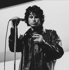 a black and white photo of a man holding a microphone in front of his face