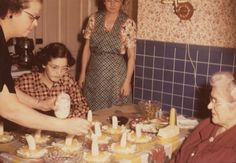 a group of people standing around a table