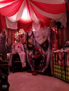 a room with red and white drapes on the ceiling, two creepy clowns sitting in chairs