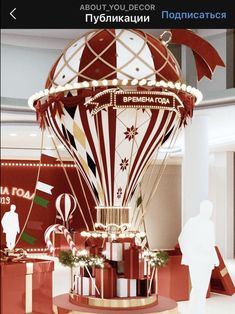 a large red and white hot air balloon with lights on it's side in a building