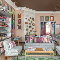 a living room filled with furniture and lots of pictures hanging on the wall above it