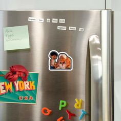 a refrigerator with magnets and stickers attached to it's door, in front of a post - it note that says new york usa