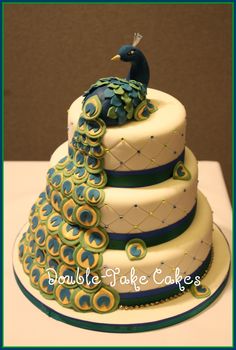 a three tiered cake with a peacock on top