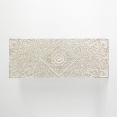 an intricately carved piece of paper on a white wall