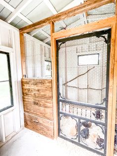 the inside of a chicken coop with wooden walls and metal bars on it's doors