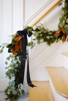 a black ribbon is tied to the banister and decorated with greenery on it