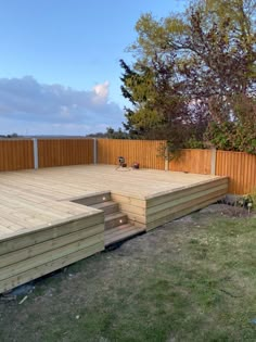 a large wooden deck in the middle of a yard