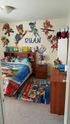 this bedroom has paw patrol wall decals on the walls and carpeted flooring