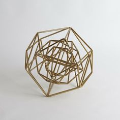 a gold geometric object on a white background with no one in it's image