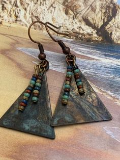 Copper and Glass Earrings. Triangular copper metal that has patina finish. Tiny earth multi-colored Czech glass beads adorn and dangle on the front. Unique handcrafted earrings. Sure to be your favorite pair! Highest Quality Craftmanship. Nickel-free Multicolor Copper Earrings, Multicolor Nickel-free Copper Earrings, Artisan Copper Beaded Earrings Nickel Free, Unique Nickel-free Copper Beaded Earrings, Unique Copper Beaded Earrings Nickel Free, Nickel-free Bronze Beaded Copper Earrings, Nickel-free Bronze Artsy Earrings, Bohemian Triangle Nickel-free Earrings, Earth Colors