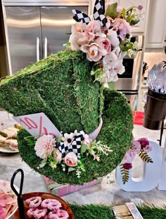 a table topped with green grass covered in flowers