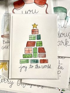 some christmas cards are laying on top of each other and have writing on them that say joy to the world