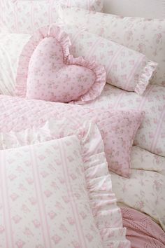 pink and white bedding with heart shaped pillows