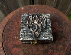 a small metal box with a dragon on it