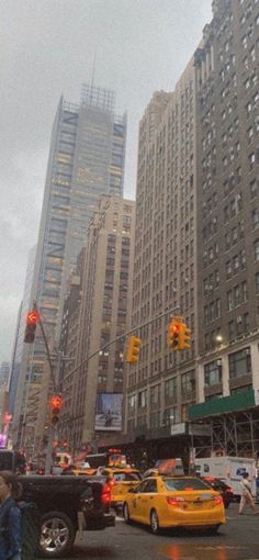 people crossing the street at an intersection in new york city, with tall buildings behind them