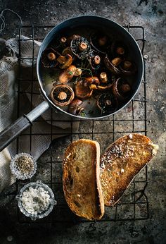 a pan filled with food sitting on top of a metal rack next to some bread