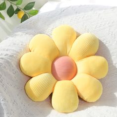 a yellow and pink flower on top of a white table cloth