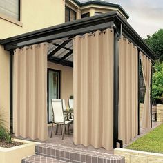 an awning with curtains on the outside of it and two chairs in front of it