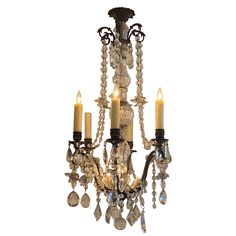 a chandelier with three candles and crystal beads hanging from it's sides