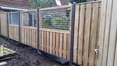 the fence is made of wood and has metal bars on each side, along with black mulch