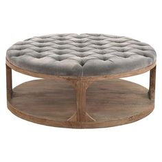 a round wooden coffee table with grey cushions