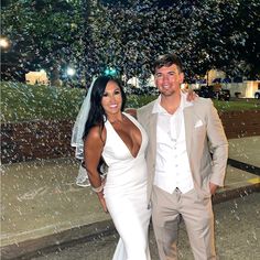 a man and woman standing in front of a fountain with bubbles coming out of it