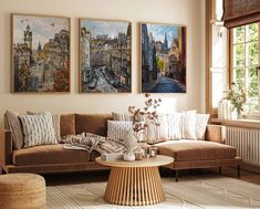 three paintings hang on the wall above a couch in a living room with a coffee table