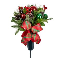 a christmas arrangement with pine cones, holly and baubes in a black vase