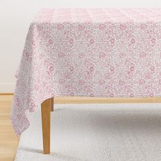 a pink and white table cloth on top of a wooden bench