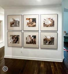 a white wall with pictures hanging on it's sides and wood flooring in front of it