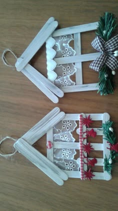 three popsicle holders decorated with lace and bows on top of a wooden table next to christmas decorations