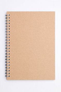 an open spiral notebook sitting on top of a white table