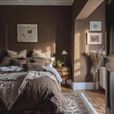 a bed sitting in a bedroom next to a dresser and lamp on top of a wooden floor